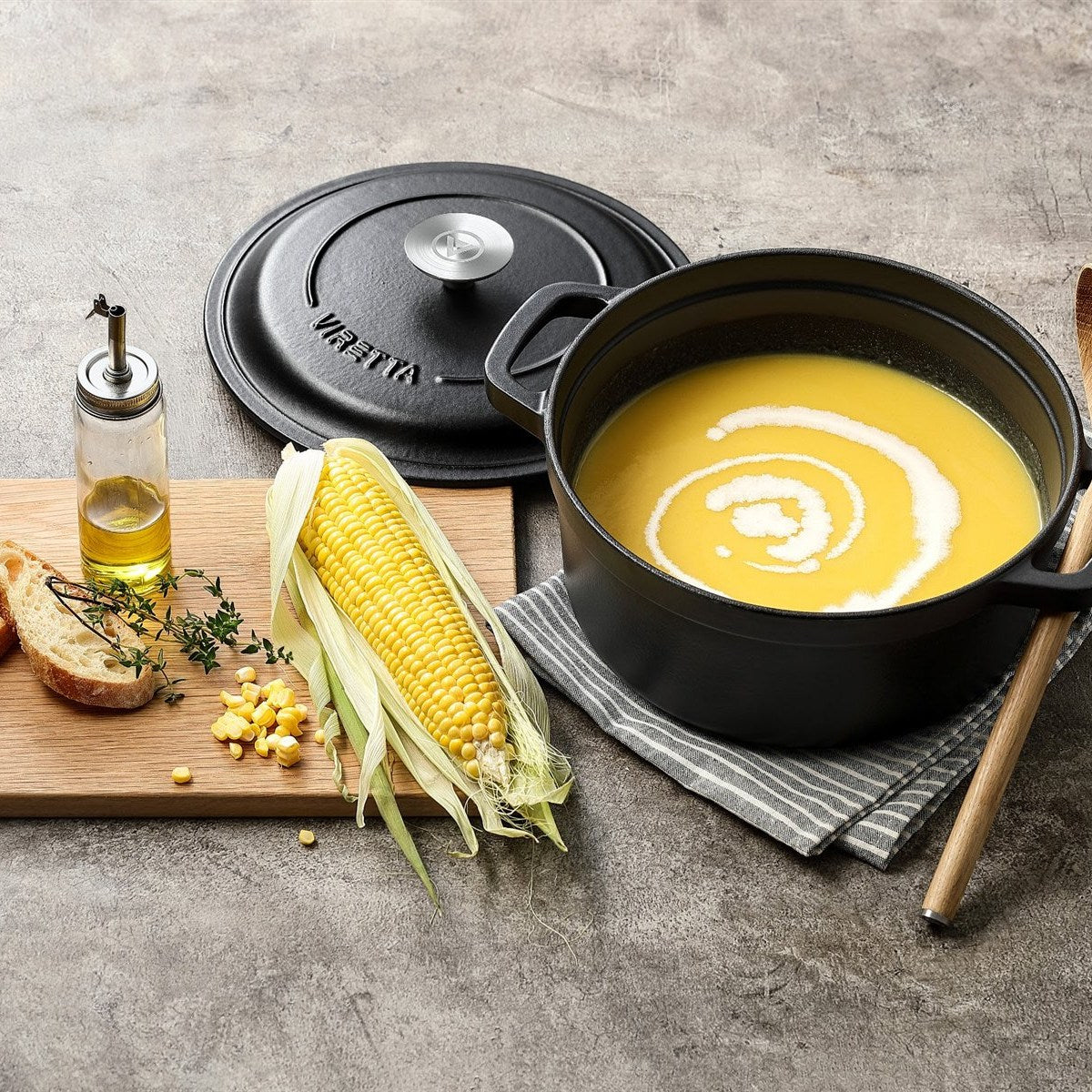 Schieferschwarzer Gusseisentopf mit Maissuppe, daneben der Deckel #Farbe_Schieferschwarz