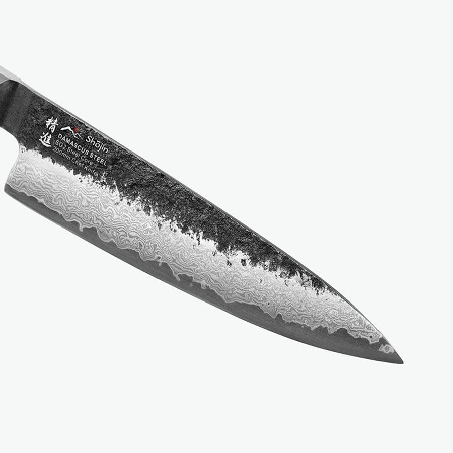 Dunkler Rücken und Damastmuster der Klinge am Shōjin Kashi Kochmesser, aus der Nähe