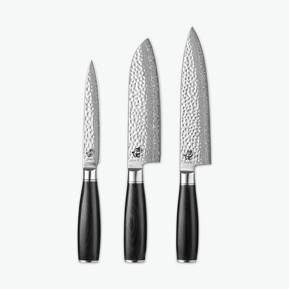 Shōjin Taru Messerset – Trio: Universalmesser, Santokumesser und Kochmesser auf hellem Hintergrund