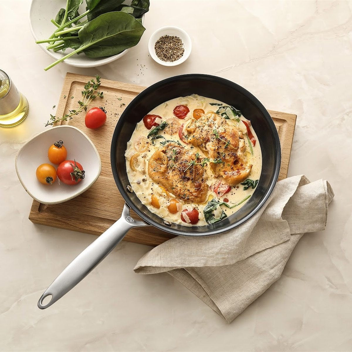 Hähnchen in Sahnesauce mit Tomaten und Spinat in der Bratpfanne 3-ply Keramik, von oben