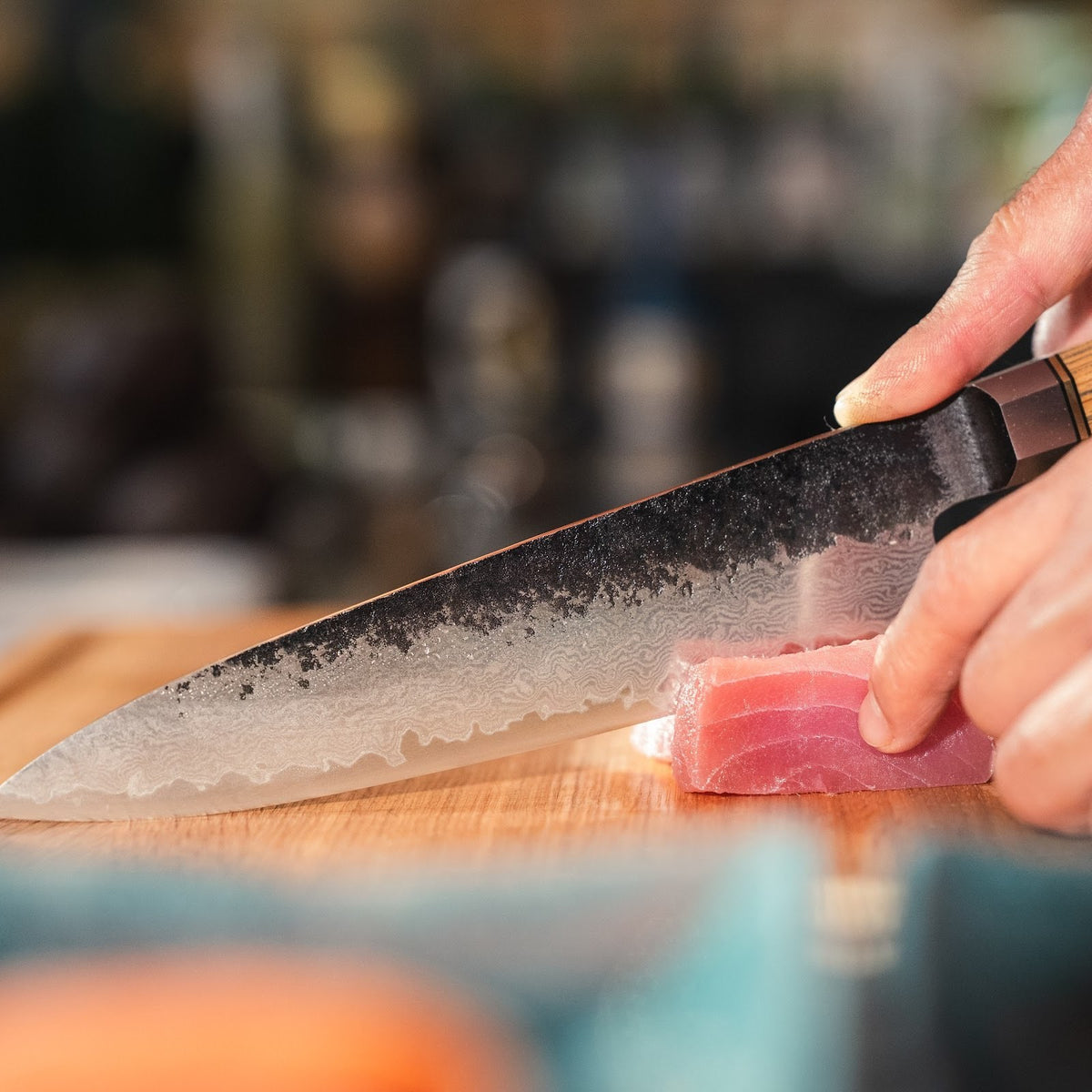 Ein Shōjin Kashi Kochmesser mit Eichengriff schneidet ein Stück Thunfisch, aus der Nähe