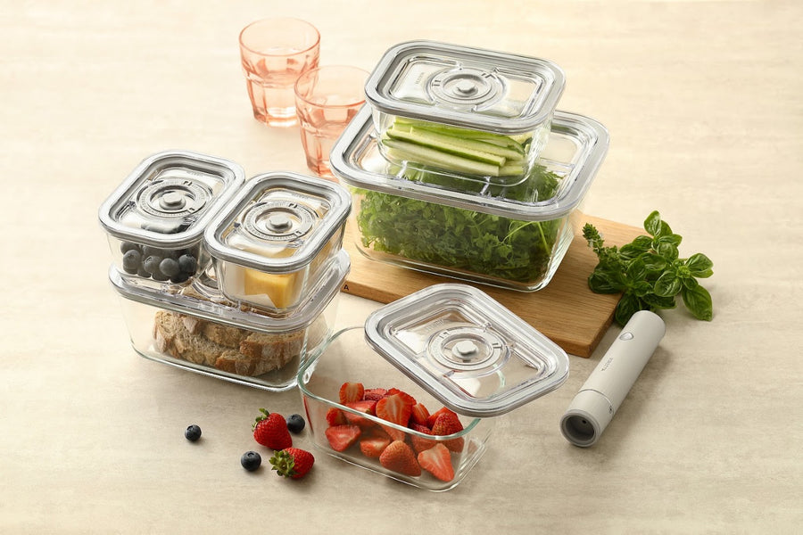 Vakuumbehälter aus Glas mit Essen und die elektrische Vakuumpumpe