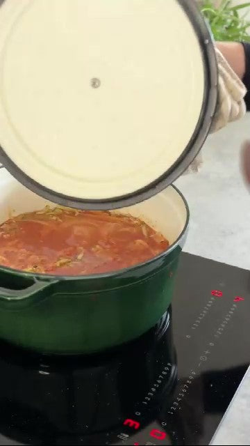 Pasta kocht in Tomatensoße in einem grünen Gusseisentopf