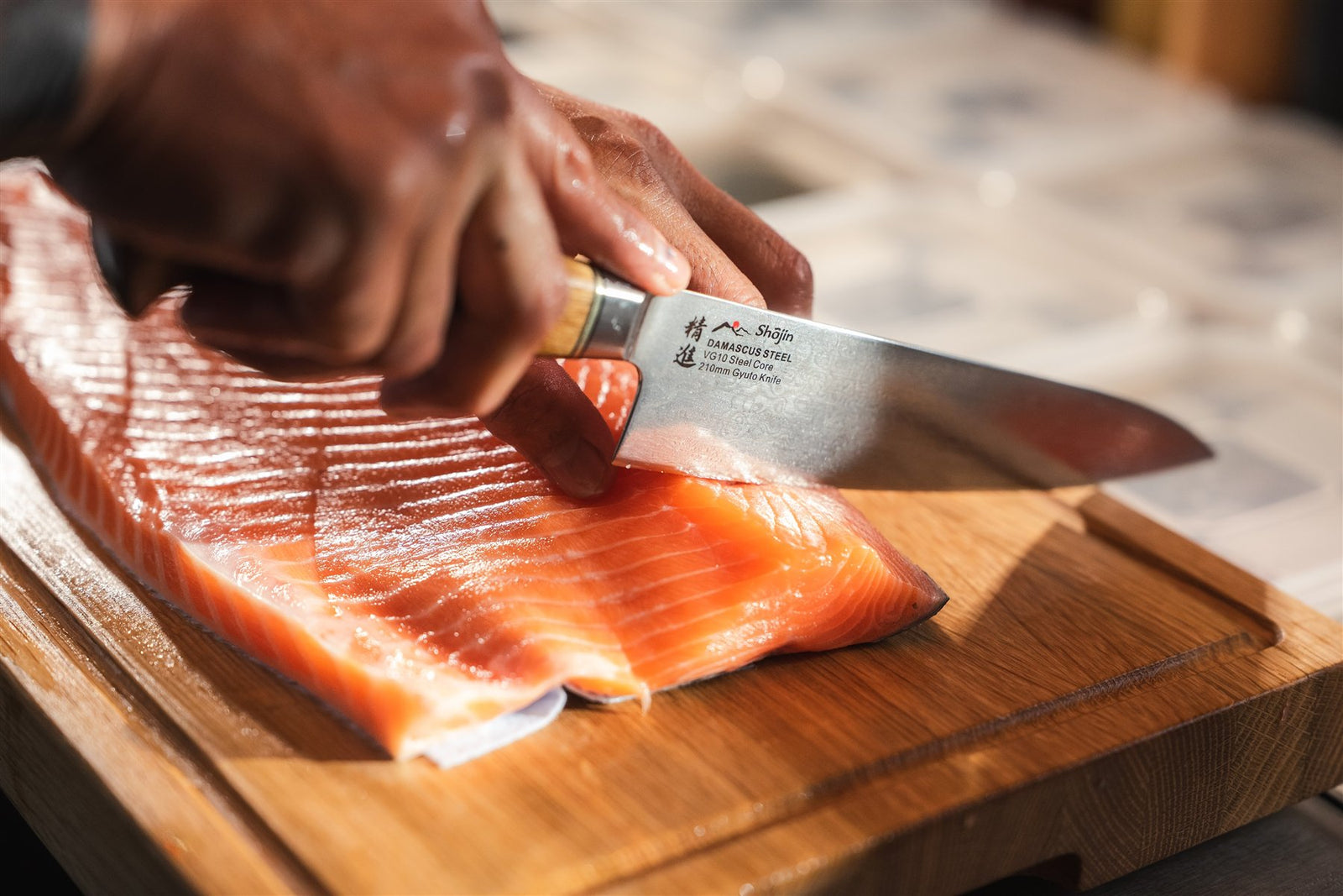 Das Kaku-Gyuto mit Griff aus Eiche schneidet Lachs